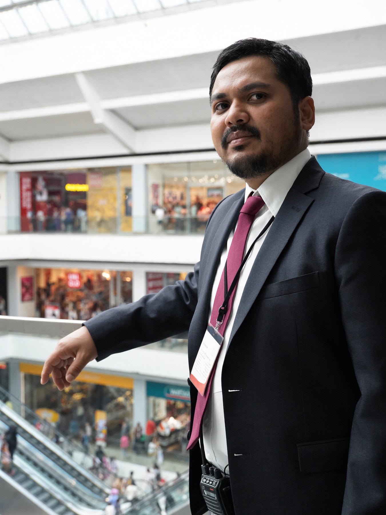 A man in a suit standing in a shopping mall atrium