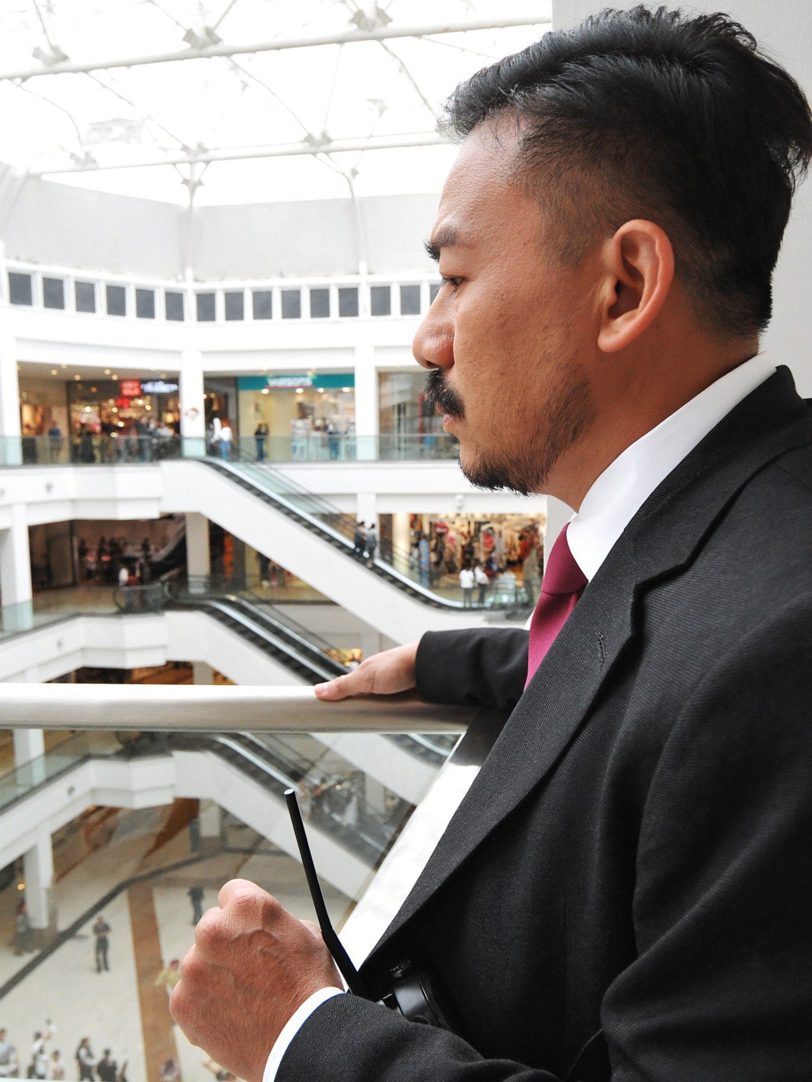 Company representative looking across a shopping centre atrium.