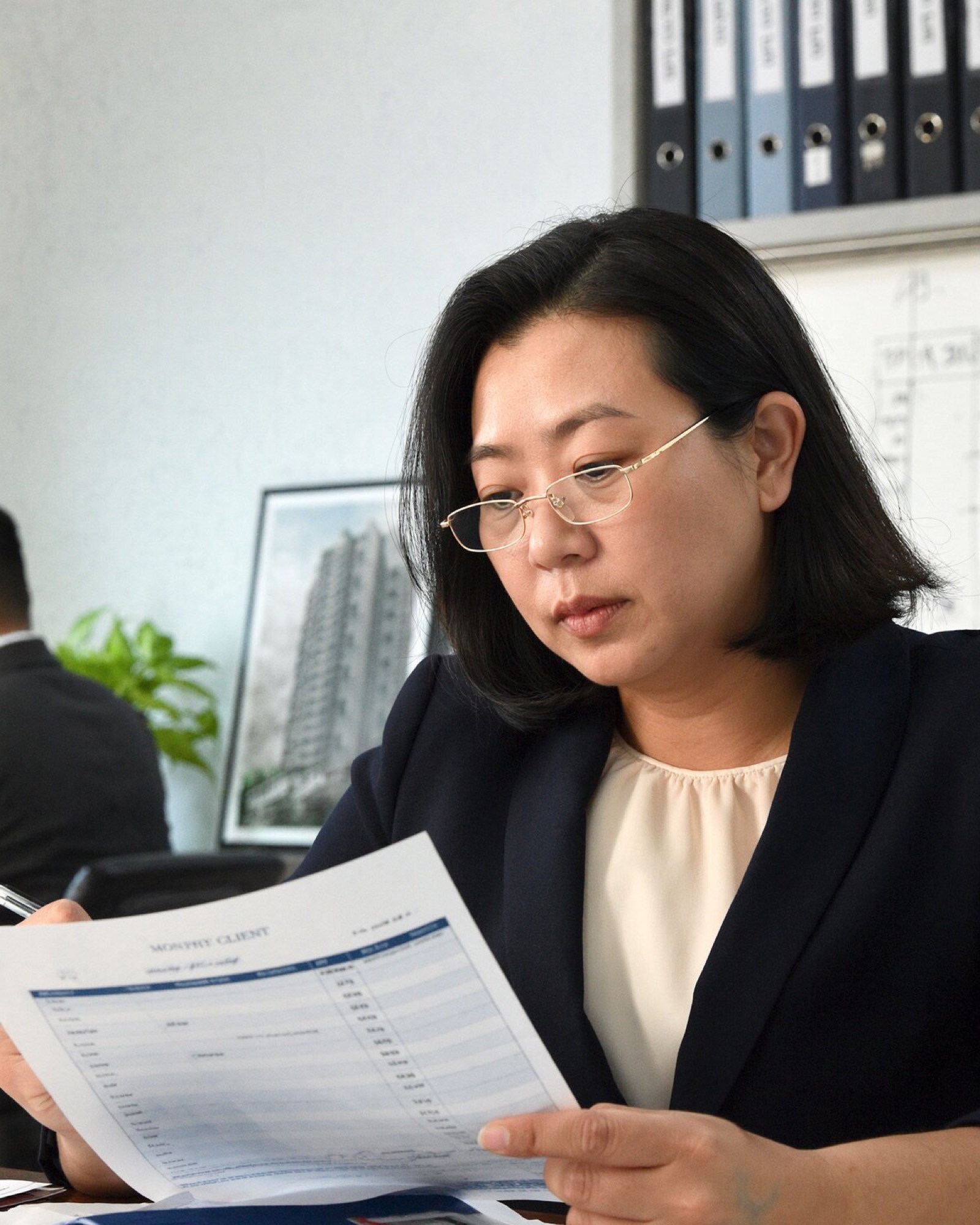 Property manager reviewing a printed report at a desk.