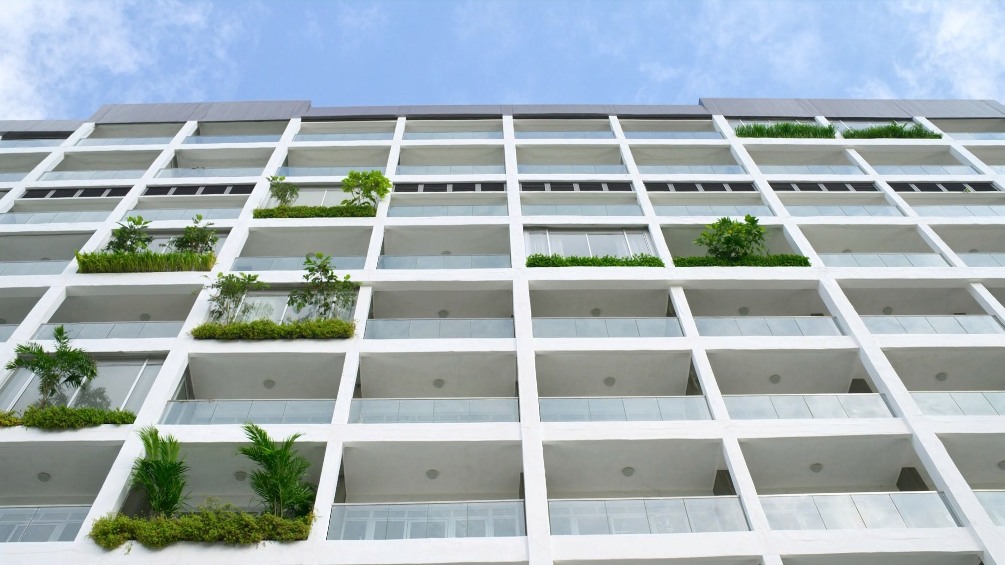 A modern Malaysian residential building framed by greenery.