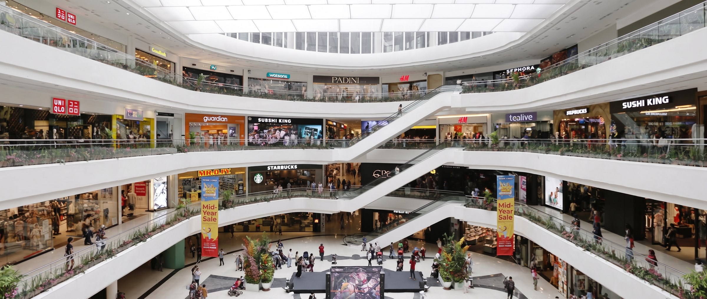 A multilevel shopping centre atrium with open walkways and escalators.
